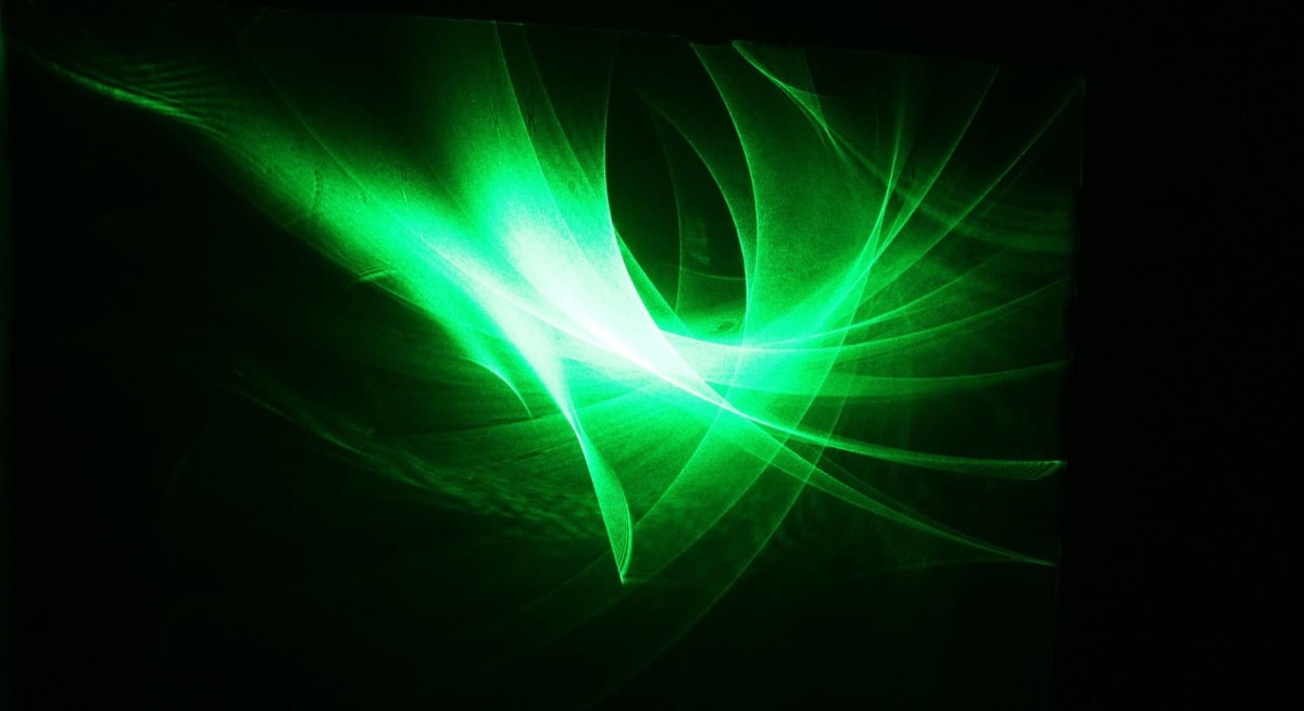 Soft, swirling green laser-light filling the projection wall — the bloom of a single bell strike.