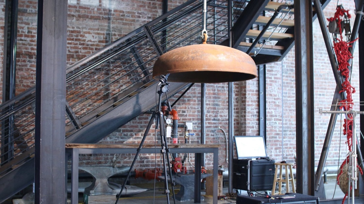 The bell, tripod microphone, and anvil rig set up in the gallery before activation.
